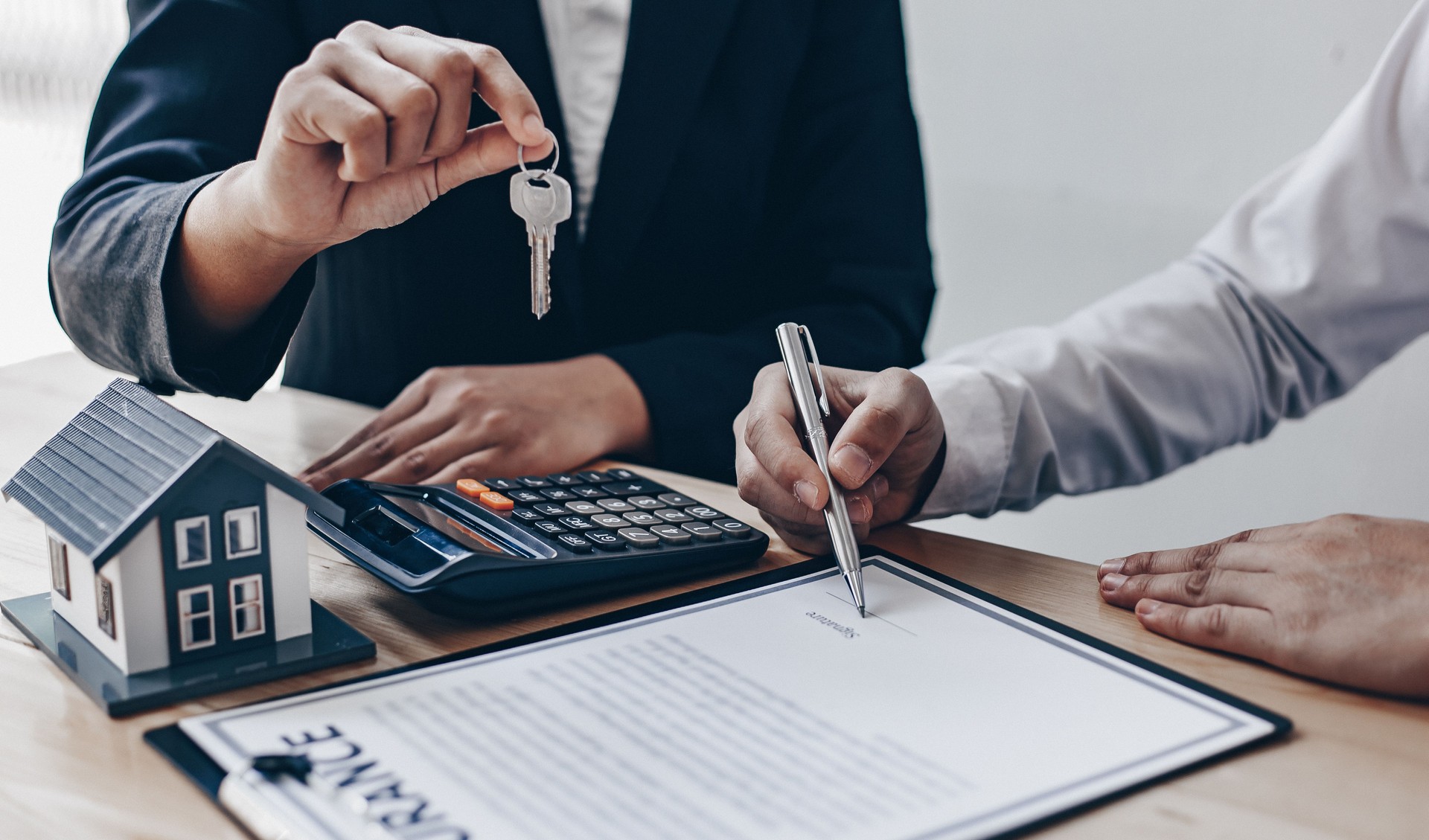 Section médiane de l’agent donnant la clé de la maison à l’acheteur au bureau